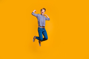 Full length body size view portrait of his he nice attractive cheerful cheery optimistic overjoyed guy in checked shirt having fun time isolated over bright vivid shine yellow background