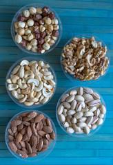 Wall Mural - Healthy food. Nuts mix assortment on stone texture top view. Collection of different legumes for background image close up nuts, pistachios, almond, cashew nuts, peanut, walnut. image