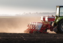  Farmer With Tractor Seeding Soy Crops At Agricultural Field
