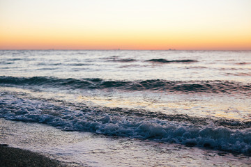 Wall Mural - Beautiful sea waves foam closeup and pink sky in sunrise light on tropical island. Waves in ocean at sunset. Tranquil calm moment. Summer vacation. Copy space