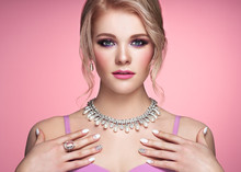 Portrait Beautiful Blonde Woman With Jewelry. Model Girl With Pearl Manicure On Nails. Elegant Hairstyle. Precious Stones And Silver. Beauty And Fashion Accessories. Perfect Make-Up. Pink Background