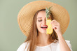 Beautiful young woman with slice of pineapple on color background