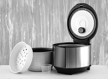 Modern Multi Cooker With Accessories On Table Against Grey Background