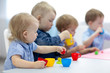 © Oksana Kuzmina - babies group learning arts and crafts in playroom with interest