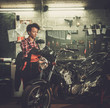 © Nejron Photo - African american woman mechanic repairing a motorcycle in a workshop
