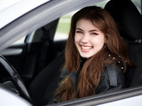 Fototapeta  - Close up portrait of young attractive red hair self-employed business woman driver sitting in white car stuck in a city traffic jam staring into camera running late to work noonday bleached colors