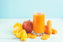 Fresh Juice From Carrots And Orange Apples In A Glass On A Wooden Blue Background. Selective Focus. Copy Space.