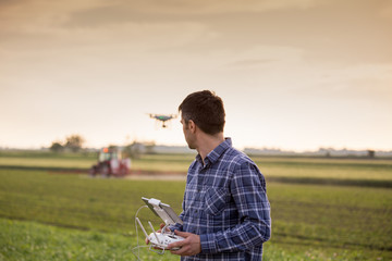 Farmer driving drone above field