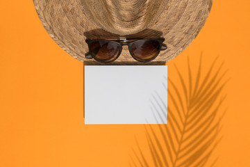 Wall Mural - Summer vacation tropical composition. Palm leaf shadow on sun hat and glasses