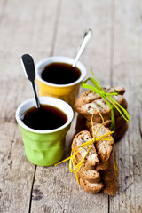 Wall Mural - Two cup of coffee and fresh Italian cookies cantuccini with almond nuts on ructic wooden table background.