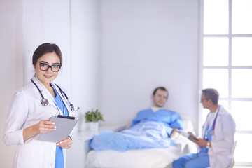 Wall Mural - Doctor checking heart beat of patient in bed with stethoscope