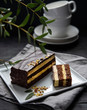 © Kufotos - delicious chocolate mozart cake with pistachious on square plate morning light  window dark background