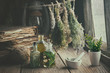 Infusion bottles, old books, mortar and hanging bunches of dry medicinal herbs. Herbal medicine. Retro styled.