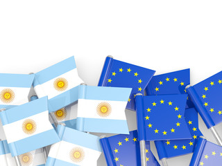 Pins with flags of Argentina and EU isolated on white.