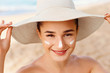 © verona_studio - Beauty Woman smile applying sun cream  on face. Skincare. Body Sun protection. sunscreen. Female in hat smear  moisturizing lotion on skin.