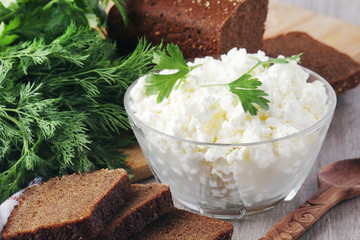 A bowl with cottage cheese and a bunch of green