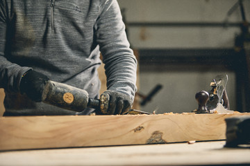 Carpenter at work on wood table with tools