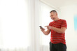 © New Africa - Portrait of emotional mature man with phone indoors. Space for text