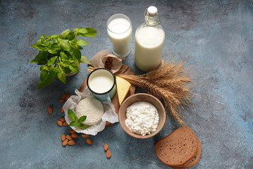 Almond milk in glass bottles with almond nuts on background. Vegan diary concept. Shavuot jewish holiday food concept - dairy products and wheat , copy space