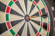 © Miguel Almeida - Accurate dart sight hitting center of target, dartboard and dart, blurred background