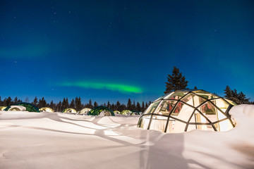 northern lignt in finland over igloo house