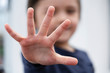 Blurry face of little boy showing five fingers at camera, Selective focus of kid primary school counting number five, Cute kid showing five numbers with fingers, Education or Toddler development conce