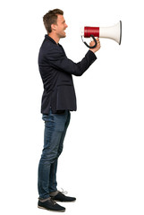 Blonde handsome man shouting through a megaphone