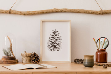 Wall Mural - Stylish and scandinavian interior of home office with mock up poster frame, wooden accessories, air plant, forest cones, notes, office and personal stuff. Minimalistic and botanical home decor. 