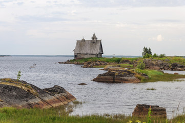 Wall Mural - Rocky shore of the White Sea with old wooden church