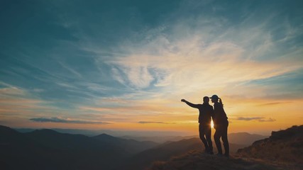 Wall Mural - the couple standing on the mountain on the sunset background