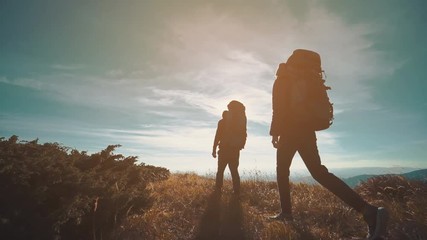 Wall Mural - the couple walking in the mountain on the sunny background. slow motion