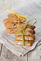 Wall Mural - Fresh Italian cookies cantuccini with almond seeds on linen napkin on ructic wooden table background.