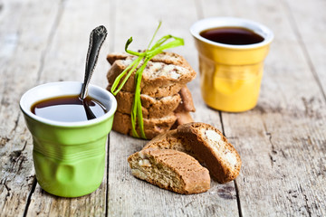 Wall Mural - Two cups of coffee and fresh Italian cookies cantuccini with almond nuts on ructic wooden table background.