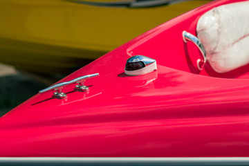 Mooring cleat and navigation light on the bow of a red boat