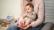 © motortion - Cute tiny newborn baby sitting barefoot on young lady lap, child skin care