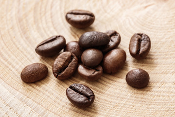 Poster - Coffee  beans on natural wooden texture background. Coffee background or texture concept.