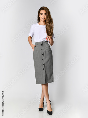 Cuadros en Lienzo Young beautiful woman posing in new white bluesque and gray skirt on high heels