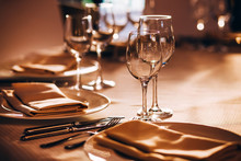 Served Table With White Tablecloth. White Plates, Wine Glass, Fork, Knife
