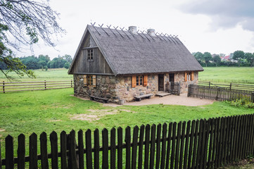 Canvas Print - Example of 19th century stone cottage with thatched roof in heritage park in Olsztynek town of Olsztyn County in Warmia-Mazury Province, Poland