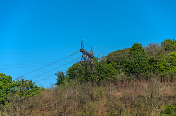 High Voltage Power Pole on a Mountain among Trees