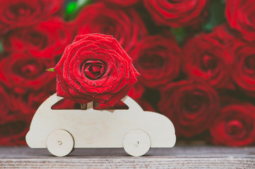 Wall Mural - Concept of flower delivery, love, typewriter transports a flower against a background of red roses.