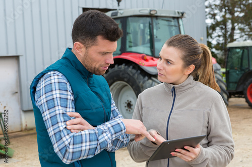 Fotografía man and woman on farm looking at digital tablet