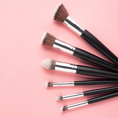 Creative concept beauty fashion photo of cosmetic product make up brushes kit on pink background.