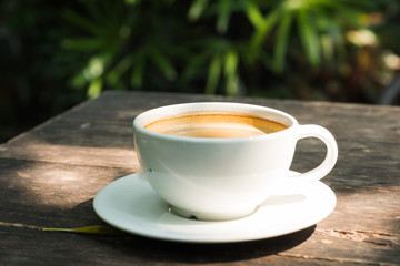 black coffee in white cup on wooden table.