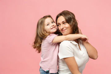 Woman in light clothes have fun with cute child baby girl. Mother, little kid daughter isolated on pastel pink wall background, studio portrait. Mother's Day, love family, parenthood childhood concept