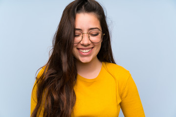 Wall Mural - Teenager girl over isolated blue wall laughing