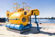 Small yellow rescue bathyscaphe with illuminators and mechanical manipulators