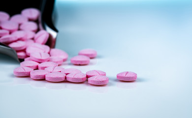 Wall Mural - Pink tablets pills on blurred background of drug tray. Pharmaceutical industry. Pharmacy products. Vitamins and supplements. Medication use in hospital or drugstore. Global drug retail market.