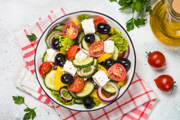 Poster - Greek salad in black plate on the table.