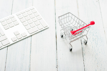 shopping cart and keypad on white wood table, web shopping background